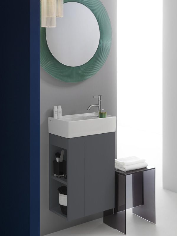 Durch intelligent eingesetzte Aussparungen kann der Platz auch in einem kleinen Bad maximiert werden. Ein Gästebadezimmer mit einem kleinen Waschtischschrank mit Aussparungen in denen platzsparend Sachen gelagert werden können.