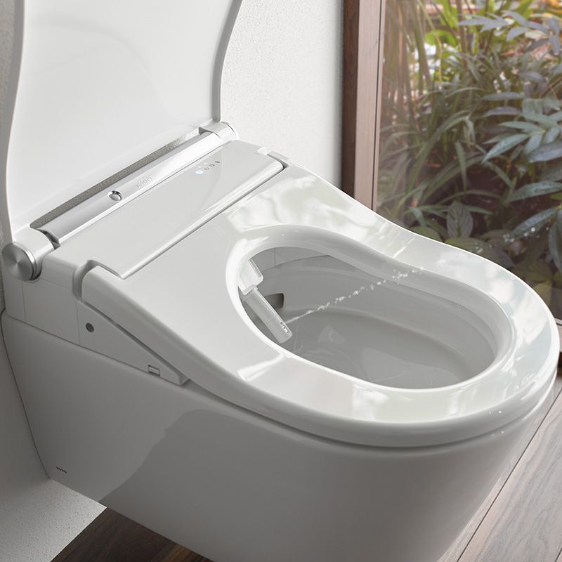 Ein offenes Washlet. Aus der aisgefahrenen Düse spritzt Wasser in einem gezielten Strahl nach schräg oben.
